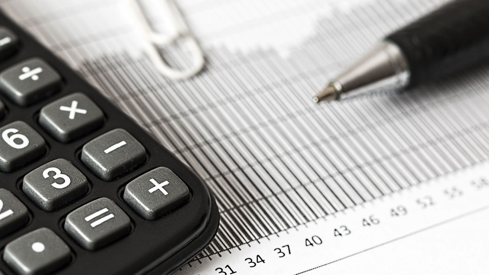 Calculadora e caneta sobre relatórios financeiros