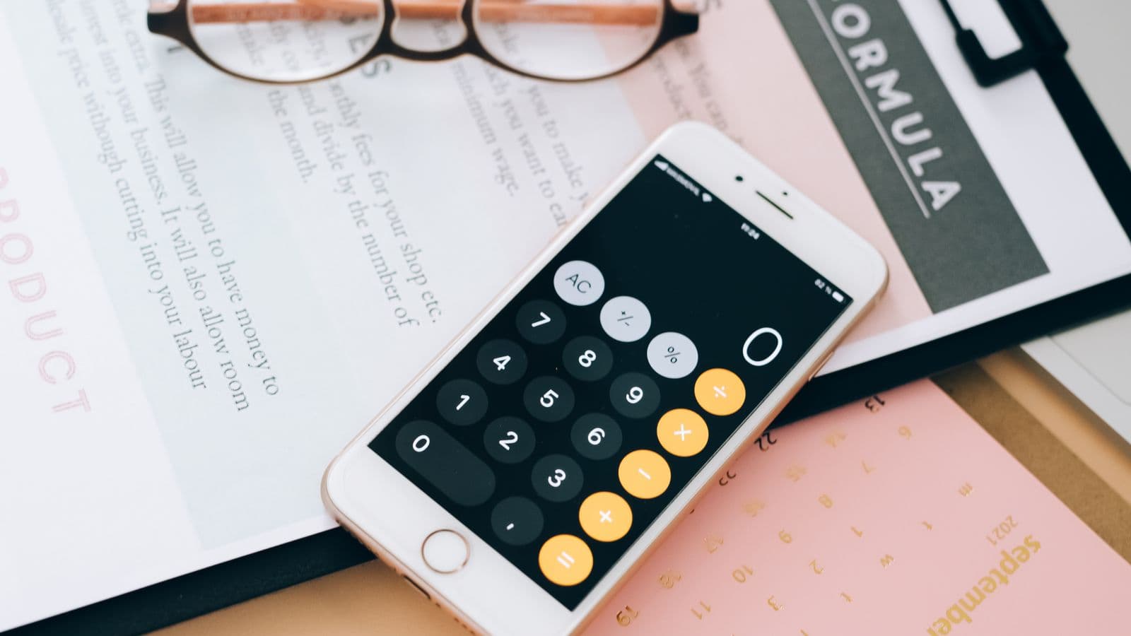 Calculadora no celular sobre papéis de planejamento